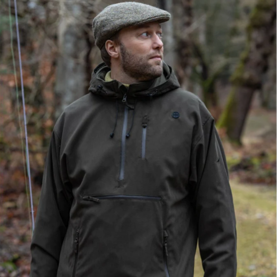 men in a dark green smock walking by a pond