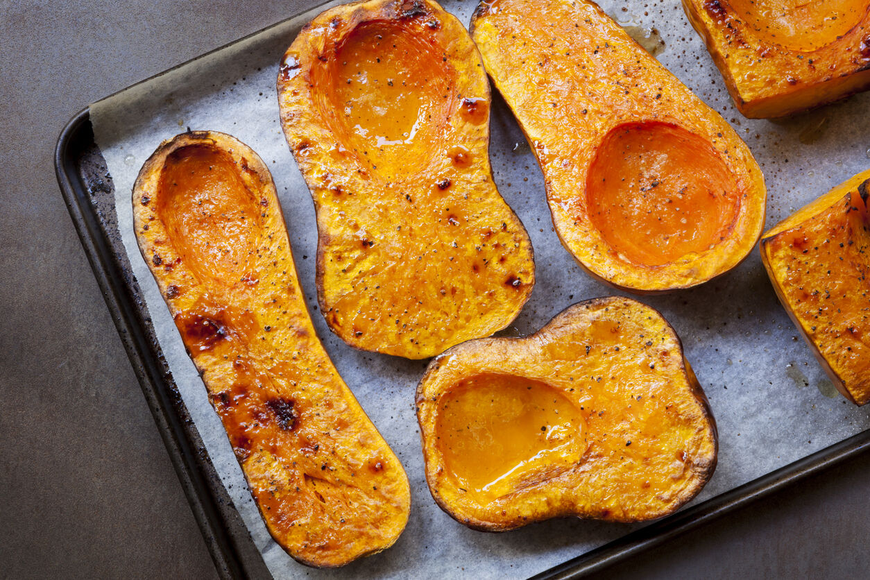 A tray of cooked butternut squash cut in half